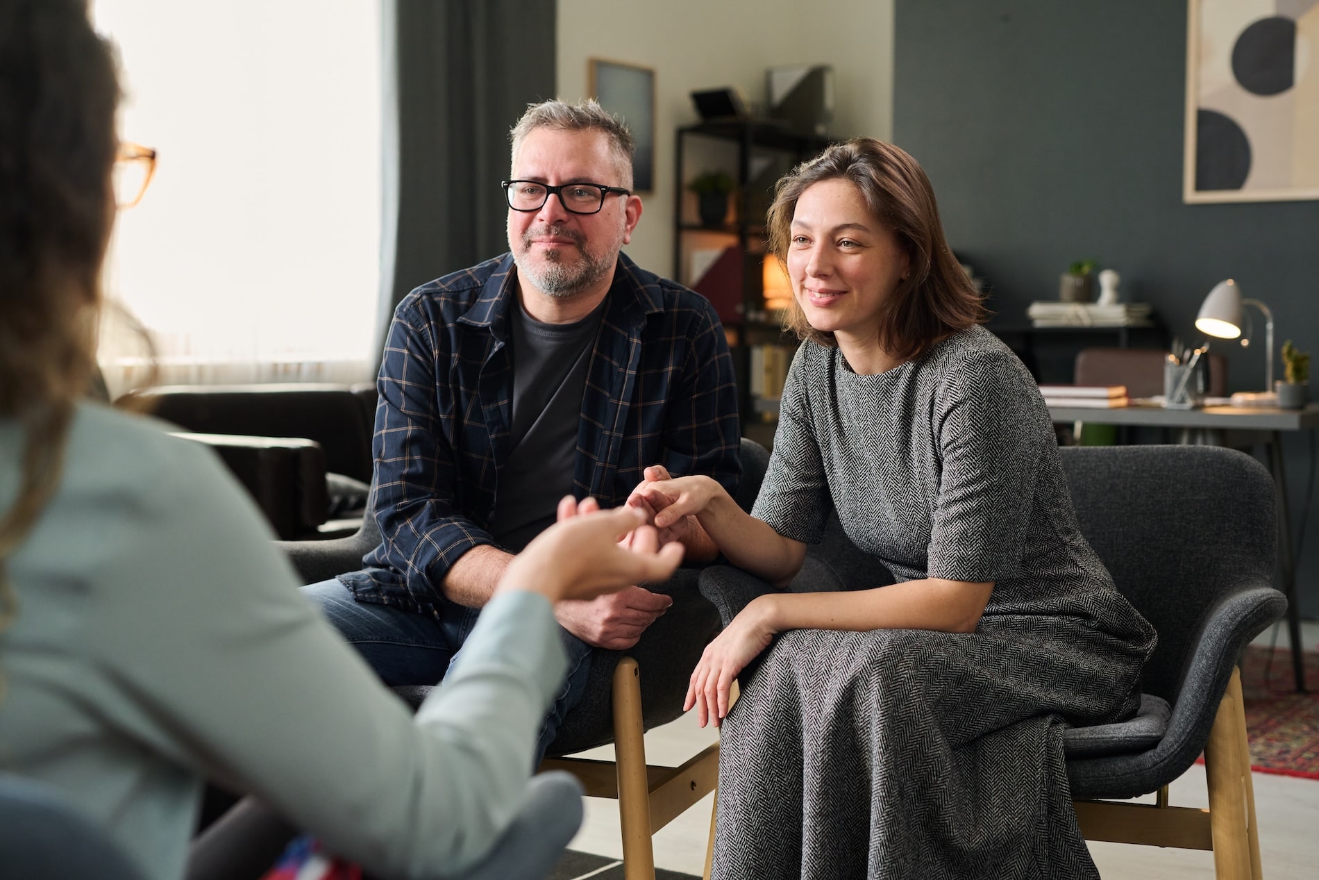 Couple in marriage counselling holding hands and listening attentively